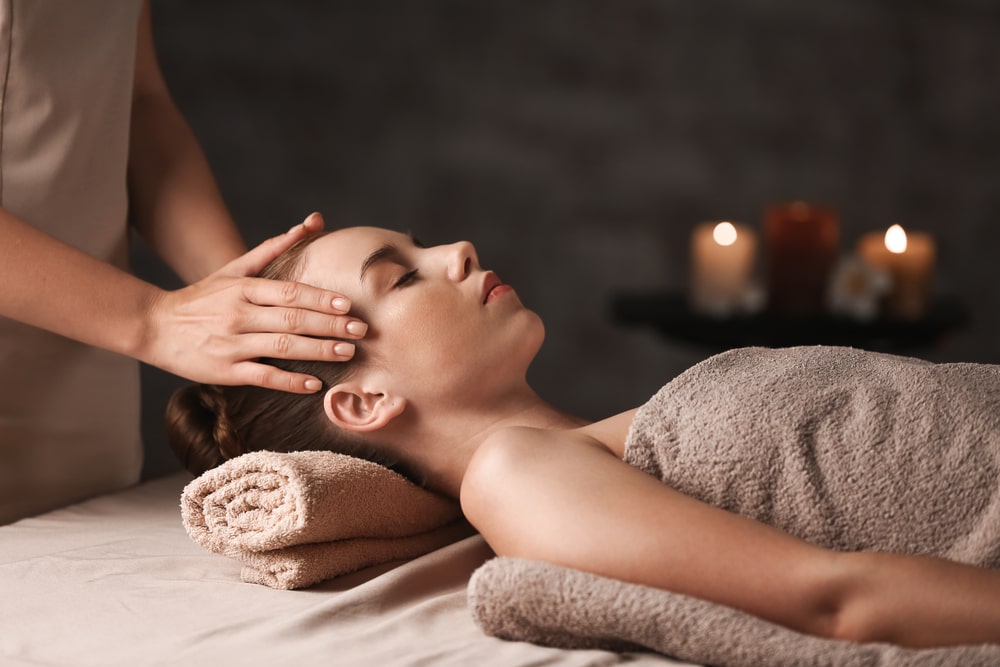Therapist applying gentle massage to client’s legs