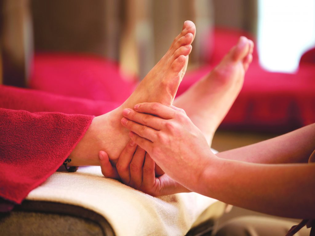 Client lying comfortably during a reflexology session at Rowan and Peridot Collective