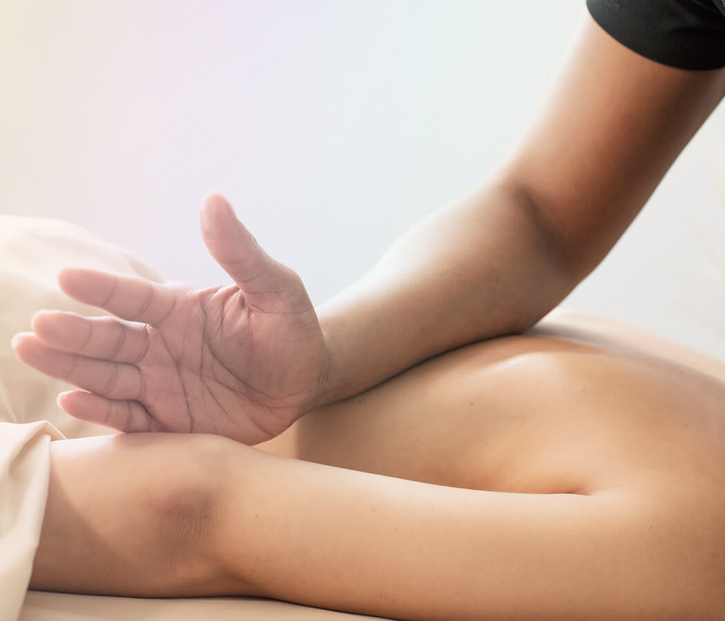 Registered massage therapist performing deep tissue massage on client's upper back at Rowan & Peridot Collective in Lethbridge