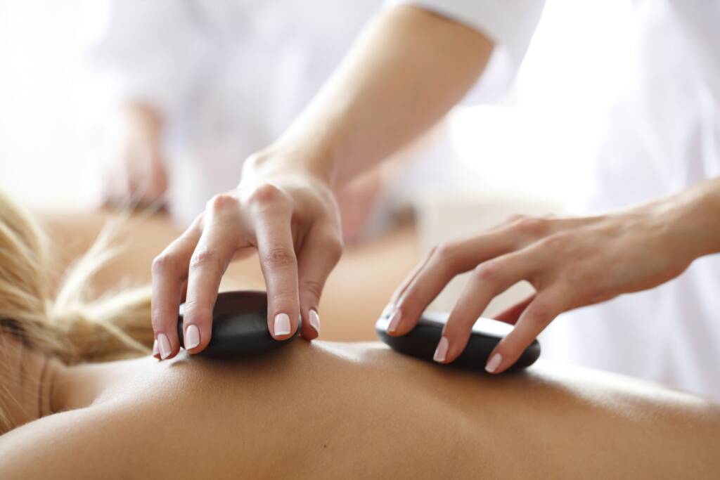 tranquil massage room setup for hot stone massage with warm lighting