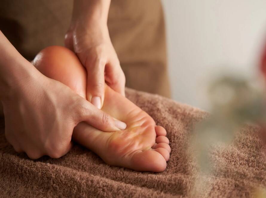 Reflexology therapist applying pressure to a client’s hands for stress relief and improved energy flow