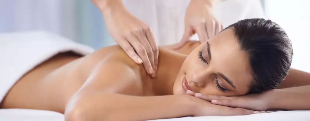 Therapist performing gentle Swedish-style strokes on client’s back