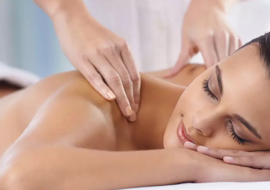 Therapist performing gentle Swedish-style strokes on client’s back