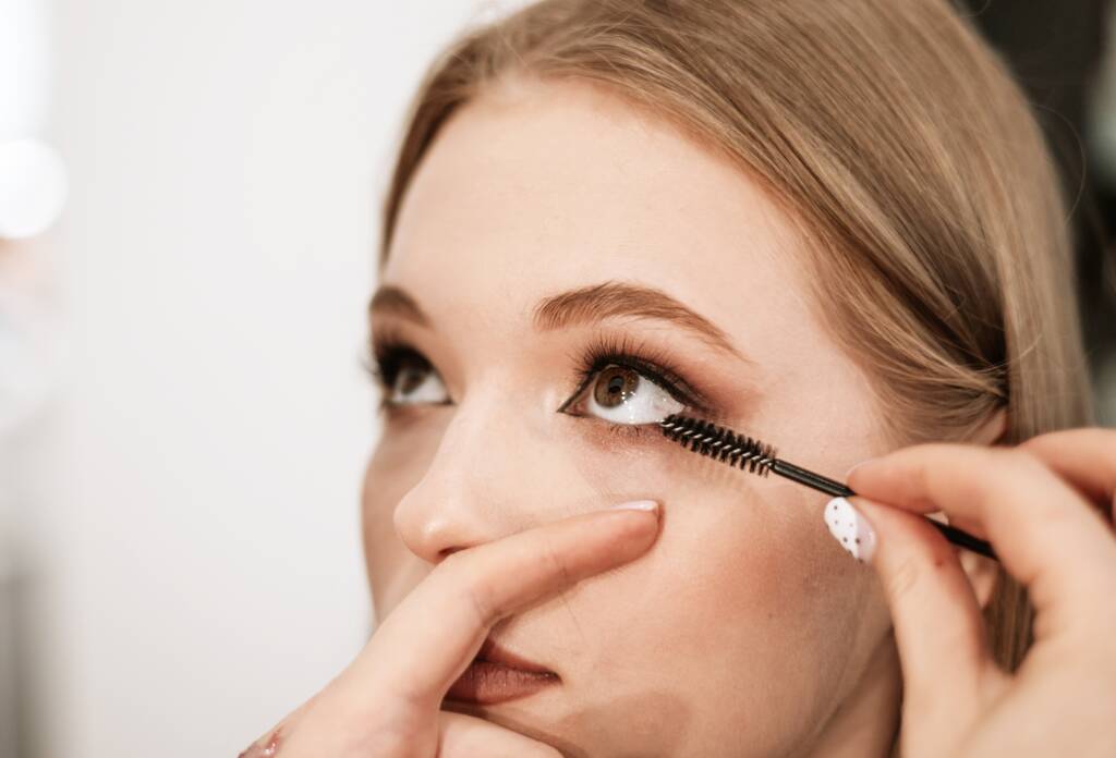 Close-up brow shaping with precise tweezer cleanup for a clean natural brow line