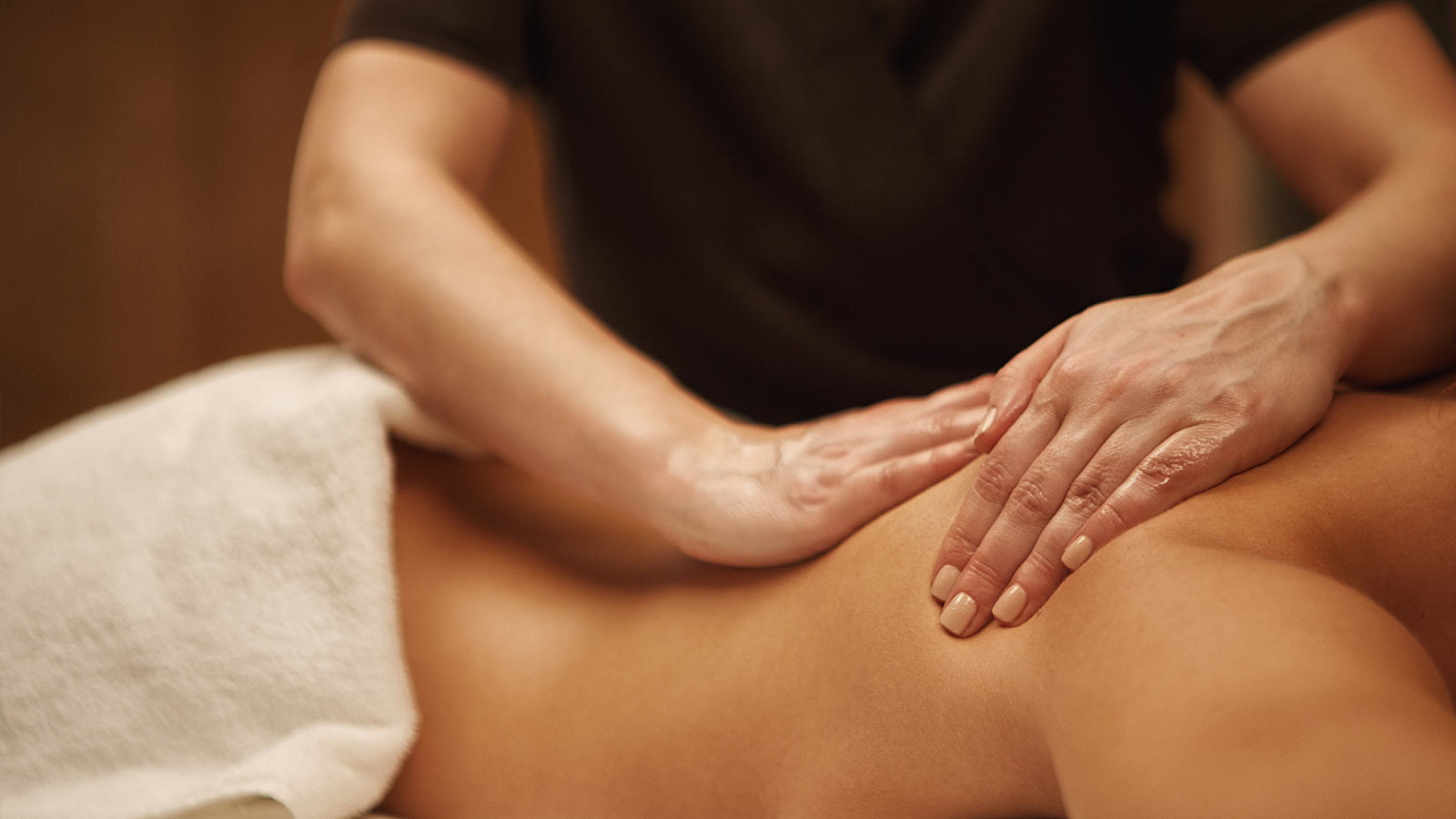 therapist performing gentle relaxation massage on shoulders with light pressure