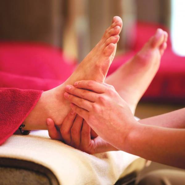 Client lying comfortably during a reflexology session at Rowan and Peridot Collective