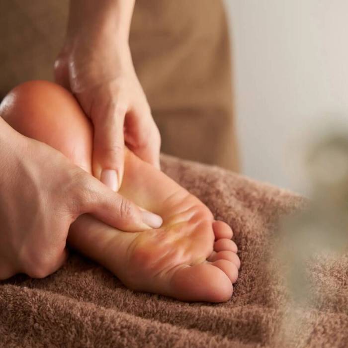 Reflexology therapist applying pressure to a client’s hands for stress relief and improved energy flow