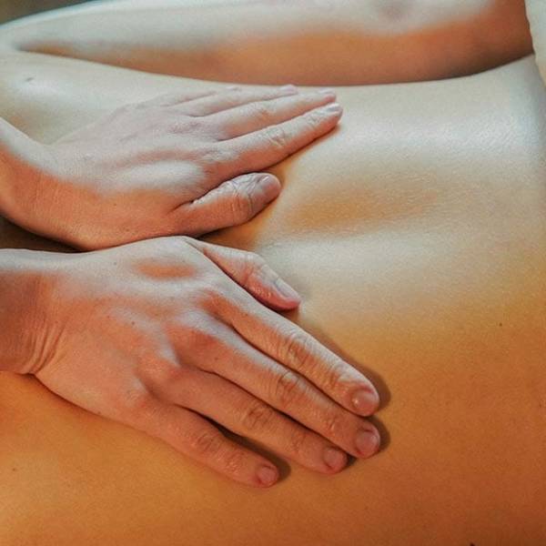 Massage therapist performing Swedish massage on a client’s back